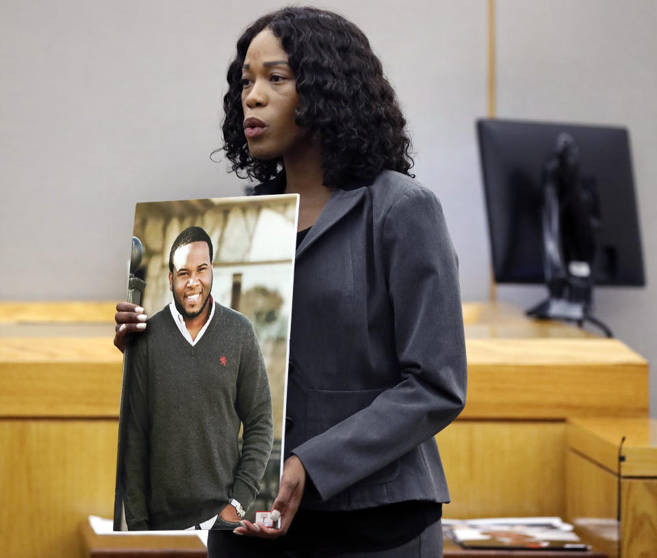 Assistant District Attorney Mischeka Nicholson shows the jury a photo of victim Botham Jean during closing remarks in the sentencing phase of former Dallas Police Officer Amber Guyger's murder trial, Wednesday, Oct. 2, 2019, in Dallas. Guyger, who said she mistook neighbor Botham Jean's apartment for her own and fatally shot him in his living room, was sentenced to a decade in prison. (Tom Fox/The Dallas Morning News via AP, Pool)