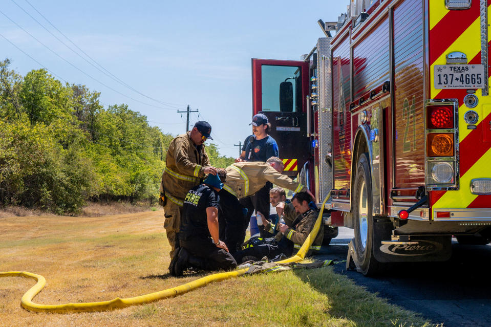 IMage: Hays County Emergency Service and Kyle and Buda Fire Departments rest and recover together while battling wildfires during scorching temperatures near Austin on Aug. 8. (Brandon Bell / Getty Images file)