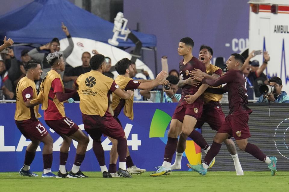 Kevin Kelsy, centro derecha, de Venezuela, celebra con sus compañeros de equipo después de marcar el gol del empate contra Argentina, durante el Preolímpuco Sudamericano de fútbol, en el estadio Brigido Iriarte, en Caracas, Venezuela, el lunes 5 de febrero de 2024. (AP Foto/Ariana Cubillos)