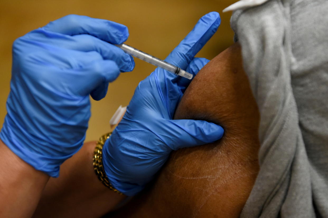 A person receives a COVID-19 vaccination in the arm. 