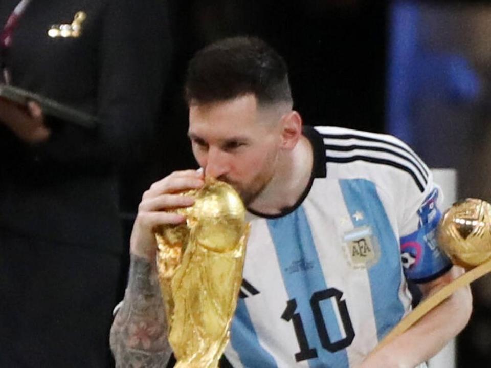 Lionel Messi mit dem WM-Pokal und dem Golden Ball als bester Spieler des Turniers Katar. (Bild: imago/APAimages)