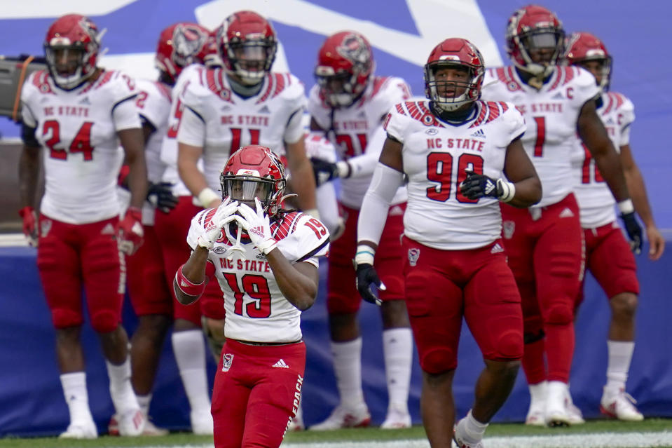 North Carolina State defensive back Josh Pierre-Louis (19) reacts with the team behind him as a penalty was called on him for roughing the passer on a play where safety Jakeen Harris (6) intercepted a pass by Pittsburgh Panthers quarterback Kenny Pickett (8) and ran it back for a touchdown in the first half of an NCAA college football game, Saturday, Oct. 3, 2020, in Pittsburgh. (AP Photo/Keith Srakocic)