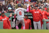 Washington Nationals' Eddie Rosario (8) is welcomed at the dugout after scoring on his two-run home run in the fourth inning of a baseball game against the Boston Red Sox, Sunday, May 12, 2024, in Boston. (AP Photo/Steven Senne)