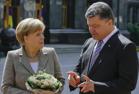 Germany's Chancellor Angela Merkel looks on as Ukraine's President Petro Poroshenko gestures in Kiev August 23, 2014. REUTERS/Gleb Garanich