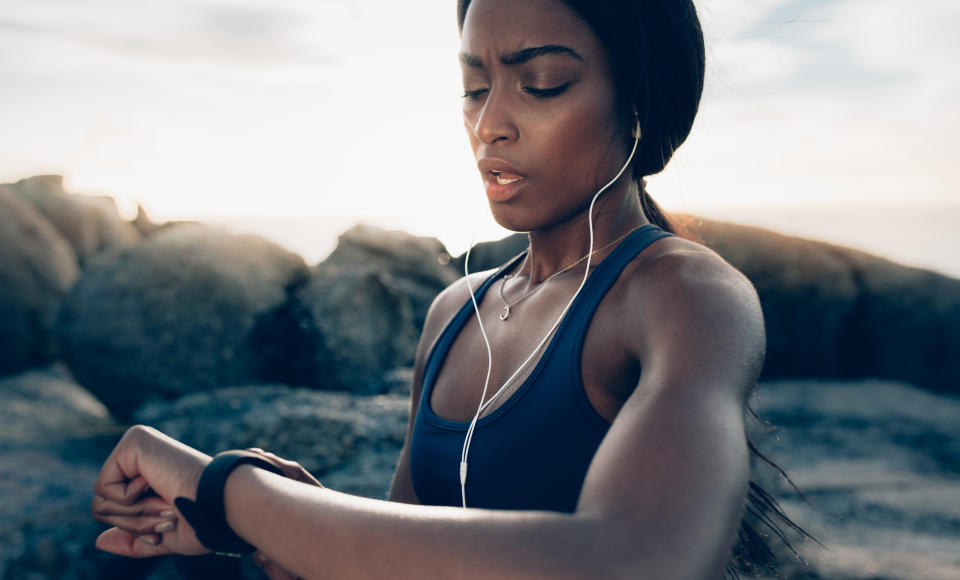 A woman checks a fitness tracker.