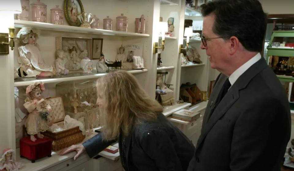 Barbra Streisand and Stephen Colbert looking at an automaton doll.