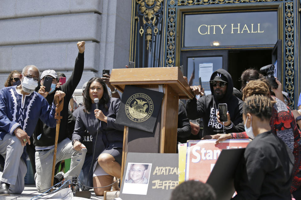 Jamie Foxx, right of podium, and Mayor London Breed, left of podium, take part in a "kneel-in" to protest police racism on the steps of City Hall, Monday, June 1, 2020, in San Francisco. Hundreds watched the noontime demonstration. (AP Photo/Eric Risberg)