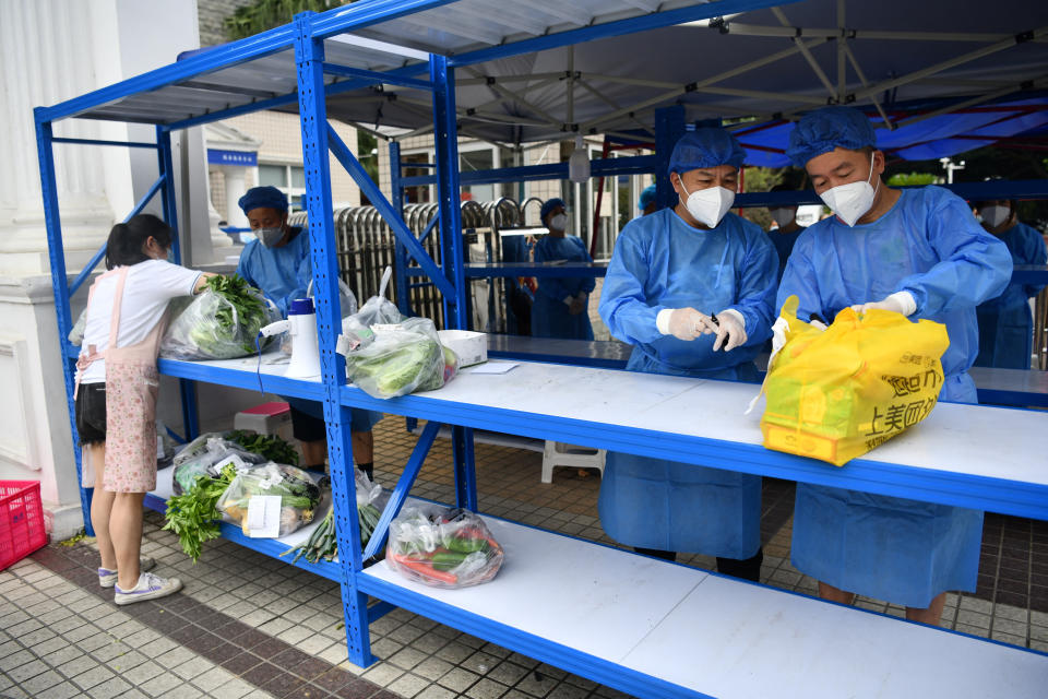 Workers in protective suits prepare to deliver food supplies placed on a rack outside a residential compound to its residents, amid a lockdown to curb the coronavirus disease (COVID-19) outbreak in Chengdu, Sichuan province, China September 2, 2022. cnsphoto via REUTERS   ATTENTION EDITORS - THIS IMAGE WAS PROVIDED BY A THIRD PARTY. CHINA OUT.