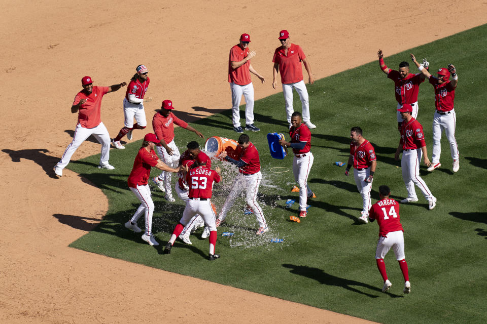 CORRECTS TO WALKOFF SINGLE NOT WALKOFF HOME RUN - The Washington Nationals celebrate after Jeter Downs hit a walk-off single during the ninth inning of a baseball game against the Oakland Athletics, Sunday, Aug. 13, 2023, in Washington. (AP Photo/Stephanie Scarbrough)