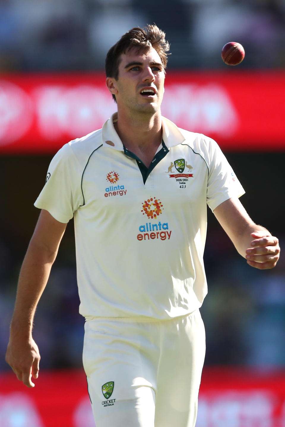 Pat Cummins throws the ball up as he prepares to bowl.