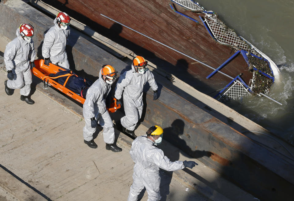 Members of a South Korean rescue team carry the body from the sightseeing boat after lifting out of Danube river in Budapest, Hungary, Tuesday, June 11, 2019. Eight people are still missing from the May 29 collision between the Hableany (Mermaid) sightseeing boat and the Viking Sigyn river cruise ship at Budapest's Margit Bridge. (AP Photo/Darko Bandic)