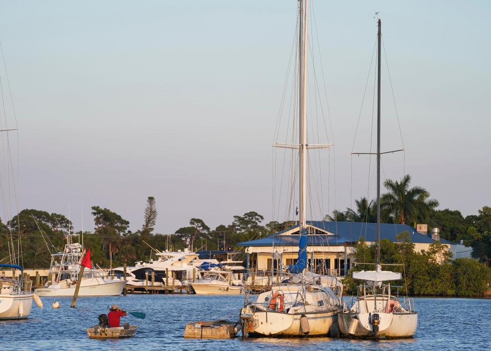 Bryan Wilson, paddles out to his sailboat house for the night Tuesday, May 17, 2022, on the Manatee Pocket in Port Salerno. The Martin County Board of County Commissioners has proposed a mooring field in this area of the Manatee Pocket. Mooring fields are permanent structures for boaters to secure their vessels.