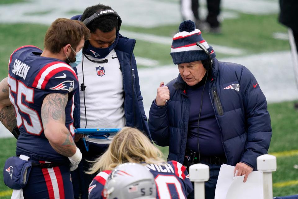 Patriots head coach Bill Belichick, right, instructs defensive lineman Chase Winovich, center, as inside linebackers coach Jerod Mayo instructs defensive end John Simon on the sideline in the first half of the Jan. 3, 2021 game against the Jets.