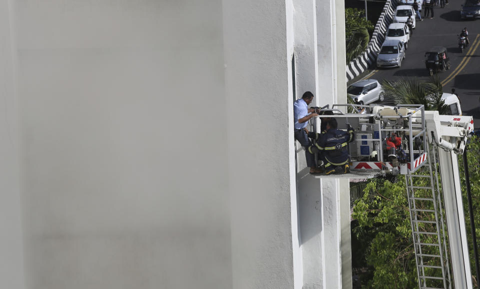 A man is rescued by firefighters from a nine-story building with offices of a state-run telephone company during a fire in Mumbai, India, Monday, July 22, 2019. (AP Photo/Rafiq Maqbool)