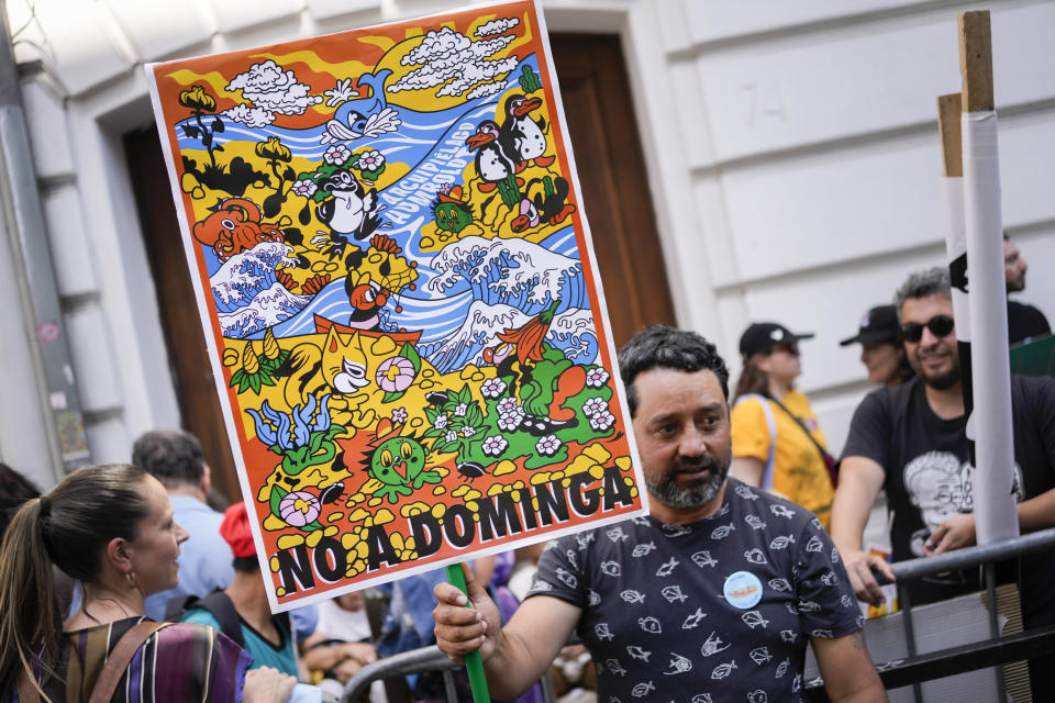 Un activista ambiental sostiene un frente al Ministerio del Medio Ambiente para mostrar su apoyo a la decisión de un comité de ministros de rechazar por unanimidad el proyecto minero Dominga en Santiago, Chile, el miércoles 18 de enero de 2023. (AP Foto/Matías Delacroix)