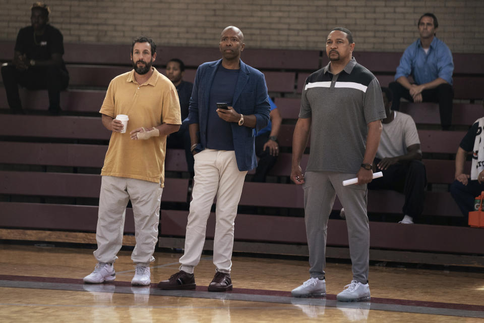 This image released by Netflix shows Adam Sandler, from left, Kenny Smith and Mark Jackson in a scene from "Hustle." (Cassy Athena/Netflix via AP)