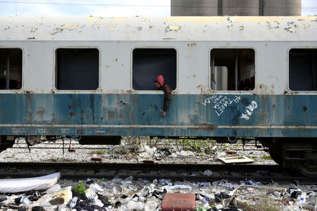 Habib, 22, from Algeria sits in an abandoned railway wagon used as a shelter by stranded migrants in the northern city of Thessaloniki, Greece, April 6, 2017. REUTERS/Alexandros Avramidis