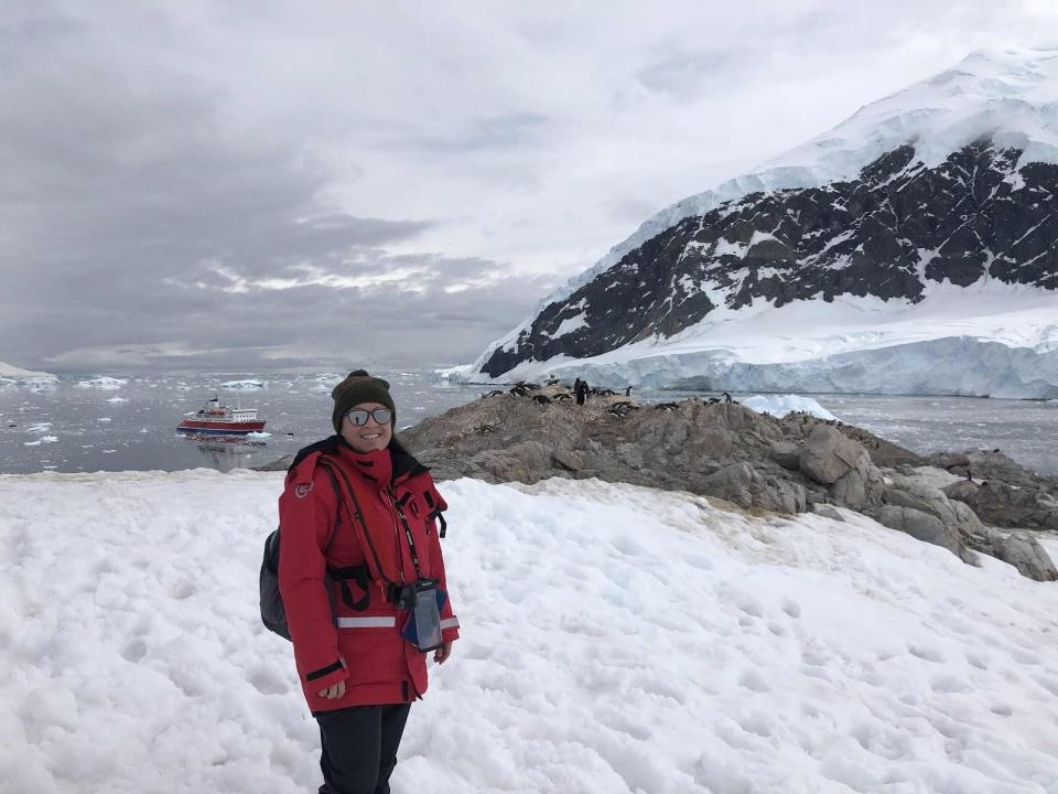 Valeria Reveles posing with penguins in Antarctica.