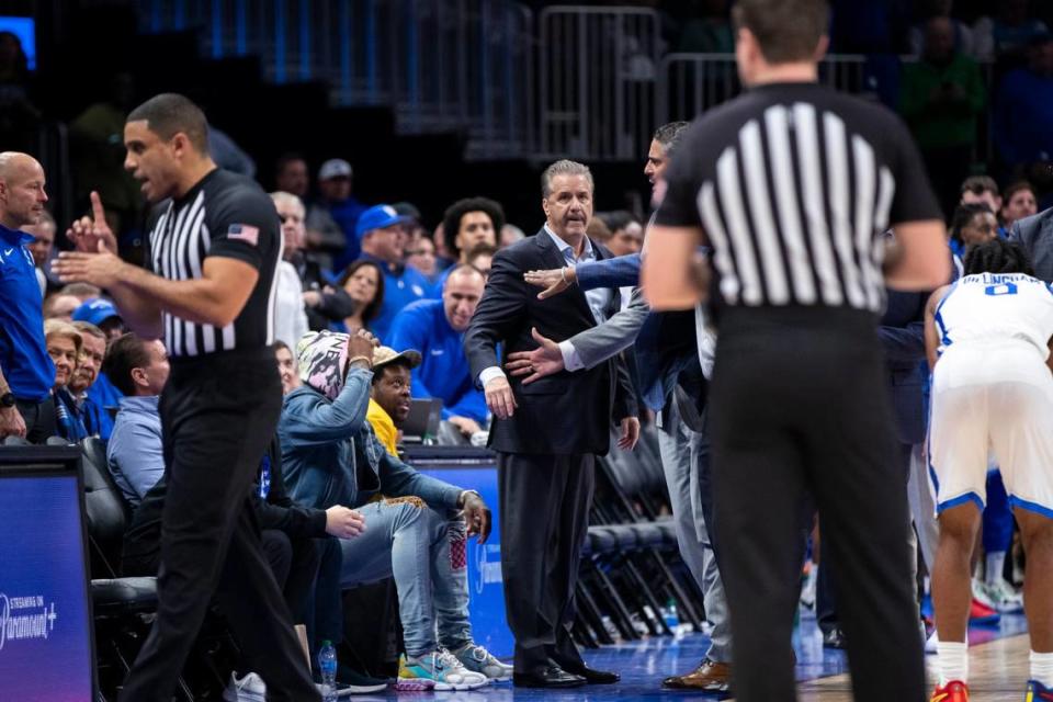 Kentucky head coach John Calipari is held back by assistant coaches during Saturday’s game against North Carolina during the the CBS Sports Classic.