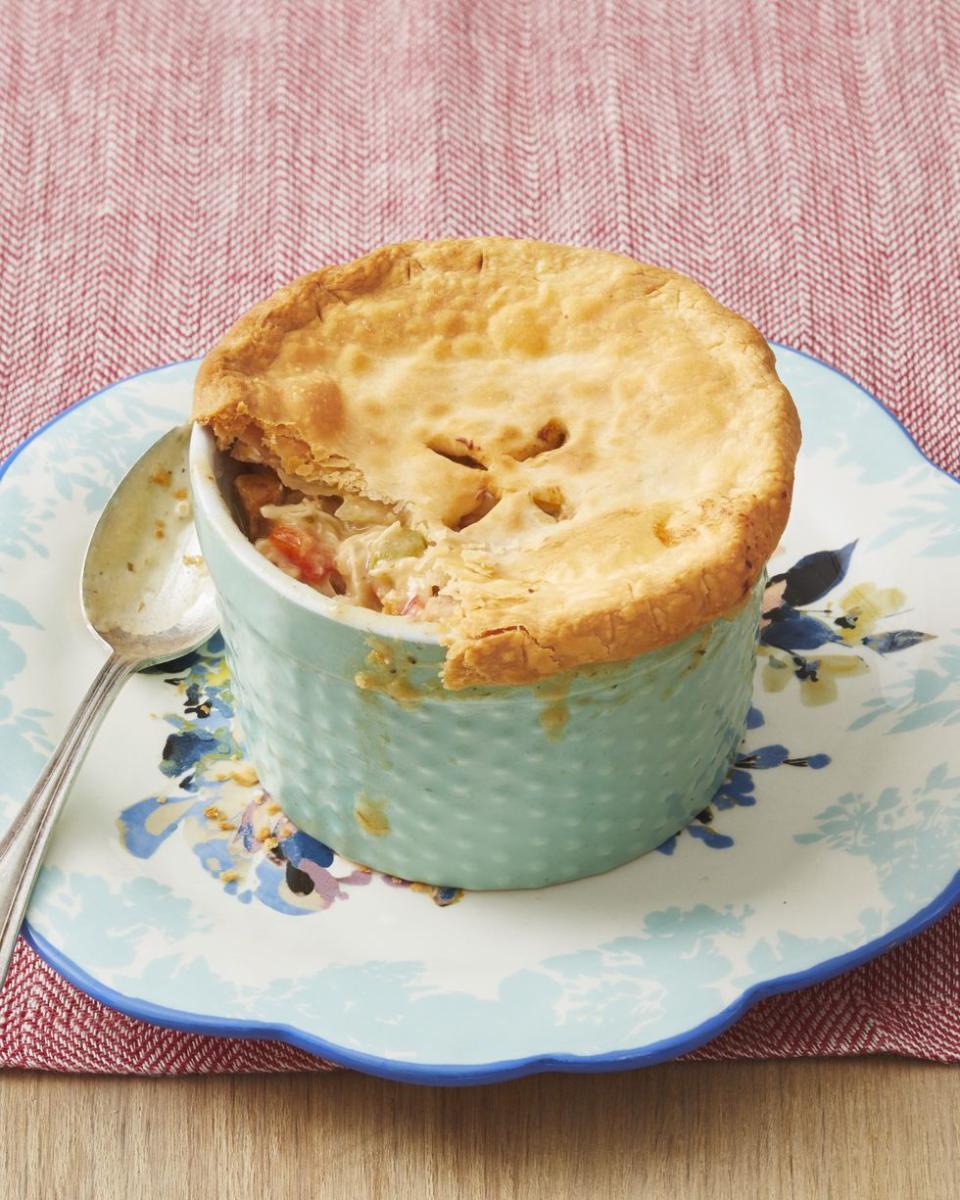 mini cajun chicken pot pies in blue ramekin on blue floral plate with spoon