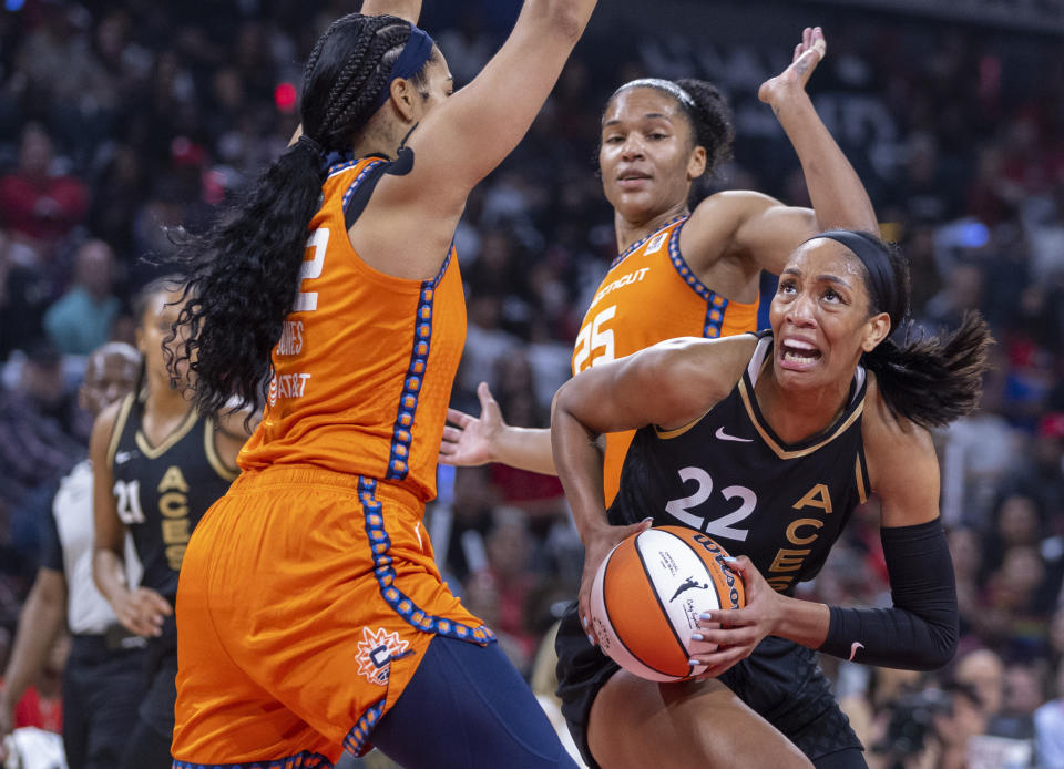 라스베가스 에이스 포워드 아자 윌슨이 9월 2022 WNBA 결승전 1차전 전반전에서 코네티컷 썬 센터 브리오나 존스(42)와 포워드 알리사 토마스(25) 사이에서 슛을 노리고 있다.  2022년 11월 11일 라스베이거스.  (AP 사진/LE Baskow)