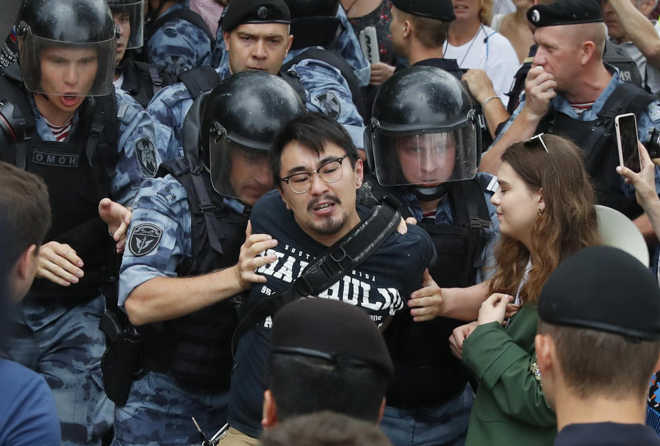 Police officers detain a protester during a march in Moscow, Russia, Wednesday, June 12, 2019. Police and hundreds of demonstrators are facing off in central Moscow at an unauthorized march against police abuse in the wake of the high-profile detention of a Russian journalist. More than 20 demonstrators have been detained, according to monitoring group. (AP Photo/Pavel Golovkin)