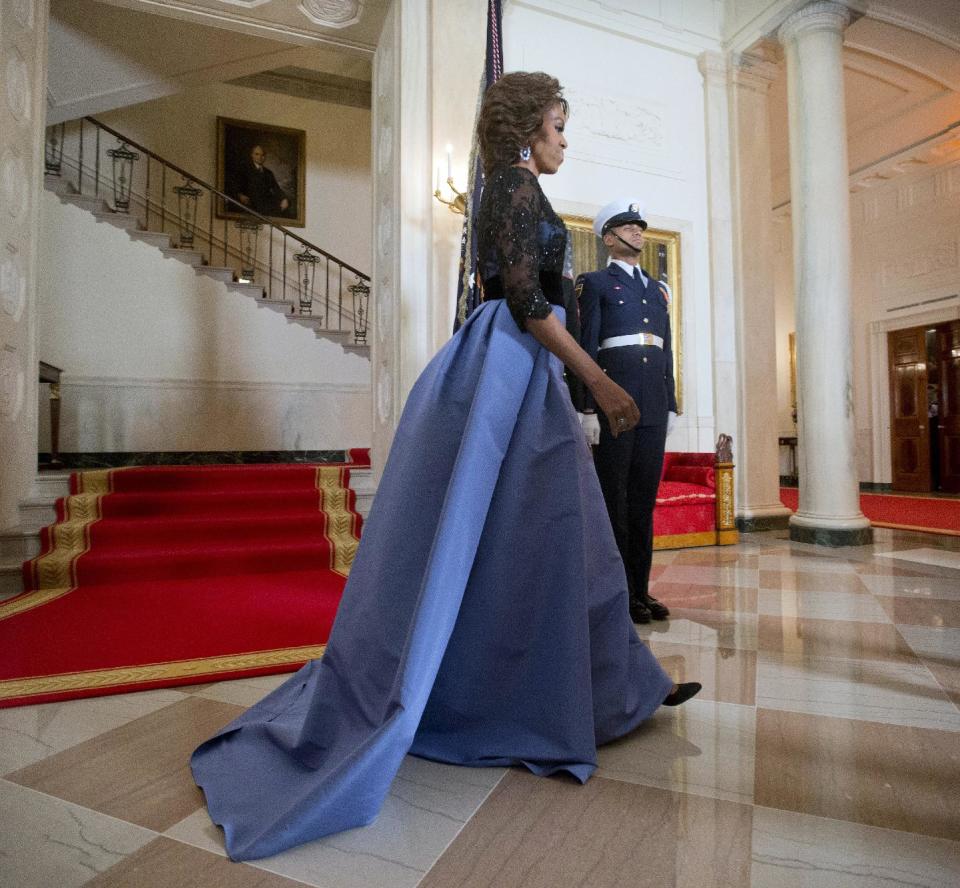 First Lady Michelle Obama walks across after posing for the official photo with President Barack Obama with French President Francois Hollande, at the Grand Staircase as they arrive for a State Dinner at the White House in Washington, Tuesday, Feb. 11, 2014. (AP Photo/Pablo Martinez Monsivais)