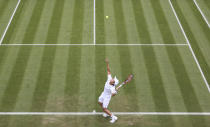 Japan's Yoshihito Nishioka serves to John Isner of the United States during the men's singles first round match on day three of the Wimbledon Tennis Championships in London, Wednesday June 30, 2021. (Adrian Dennis/Pool via AP)