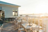 <p><strong>What will we notice when we walk in?</strong> The elevation of this rooftop bar isn’t anything to write home about as you’re only a couple of stories up. However, its location on the tip of Patriots Point in the <a href="https://www.cntraveler.com/hotels/mount-pleasant/the-beach-club-at-charleston-harbor-resort-and-marina?mbid=synd_yahoo_rss" rel="nofollow noopener" target="_blank" data-ylk="slk:Charleston Harbor Resort;elm:context_link;itc:0;sec:content-canvas" class="link ">Charleston Harbor Resort</a> delivers some seriously alluring views, with the harbor, Ravenel Bridge, the Battery and panoramas all the way out to Fort Sumter all laid out for your approval. An aesthetic shaped by the reclaimed wood interiors parlays into a casual seaside chic, the open-plan design meaning that the bar area opens out onto that scenic terrace.</p> <p><strong>How’s the crowd?</strong> The resort is a relatively luxurious waterfront hotel, and so there’s a steady stream of vaguely affluent guests drinking here at any one time. Despite the upscale backdrop, though, there’s a casual, vacation-friendly vibe and outside of occasional couples celebrating an anniversary at the attached restaurant, formality levels are low. It’s a slightly more mature crowd than some of the downtown rooftop spots, with a civilized appreciation of the wonderful vistas preferred to noisy rounds of tequila shots.</p> <p><strong>How are the drinks?</strong> As an annex to the seafood restaurant next door, the bar has a suitably versatile and comprehensive wine list that draws heavily on bubbles and whites. A good number of French wines mix with Californians, the latter making up more of the reds. The cocktail menu is a solid selection of classics such as mojitos, margaritas and Moscow Mules, and the draft beer selection rotates regularly along with a couple of bottles for craft connoisseurs.</p> <p><strong>What do they have to eat?</strong> The bar serves a pared-down version of its wonderful seafood menu, and guests can eat at the bar. Many of them order the incredibly fresh ‘peel and eat’ shrimp, or the fried shrimp platter. A light but tasty crab cake sandwich is also a winner, and there’s even the healthy(ish) fusion of a tuna poke tostada. Burgers and chicken tenders round out the options, but the seafood is where the kitchen shines.</p> <p><strong>Did the staff do you right?</strong> Any traces of formality fade into the distance, and the bar staff create an ‘island time’ ambience without tripping into tackiness. They’re knowledgeable and professional but happy to indulge a whimsical journey into their own cocktail creations by way of a few questions about preferred flavors.</p> <p><strong>Wrap it up: what are we coming here for?</strong> In terms of sundowners against a backdrop of spectacular sunsets, the Bridge Bar really sets the standard in Charleston. The sheer breadth of the views is among the best in town, and the harborside setting elevates the place in terms of relaxation and calm. Add to this a solid drinks menu and plates of fresh seafood, and you’ve got a prize catch right there.</p>