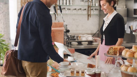 A customer checking out at a bakery counter