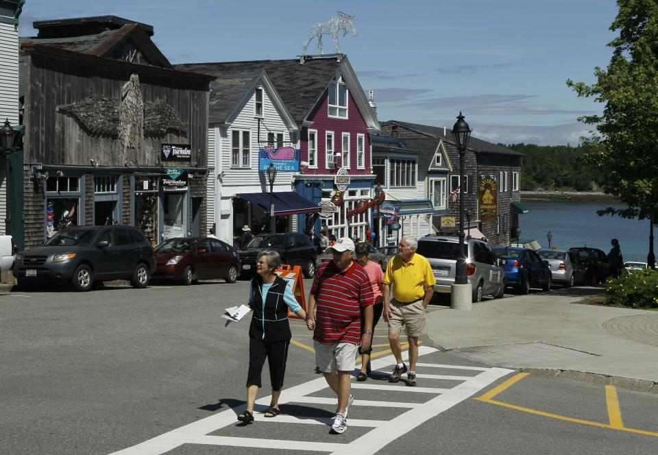 FILE-In this June 4, 2010 file photo, tourists stroll through Bar Harbor, Maine. The town plans to begin charging to park next month, eliminate all-day free parking on downtown side streets. The move comes amid ever-increasing seasonal traffic to Bar Harbor and Acadia National Park, which set a visitation record in 2018.(AP Photo/Robert F. Bukaty, file)