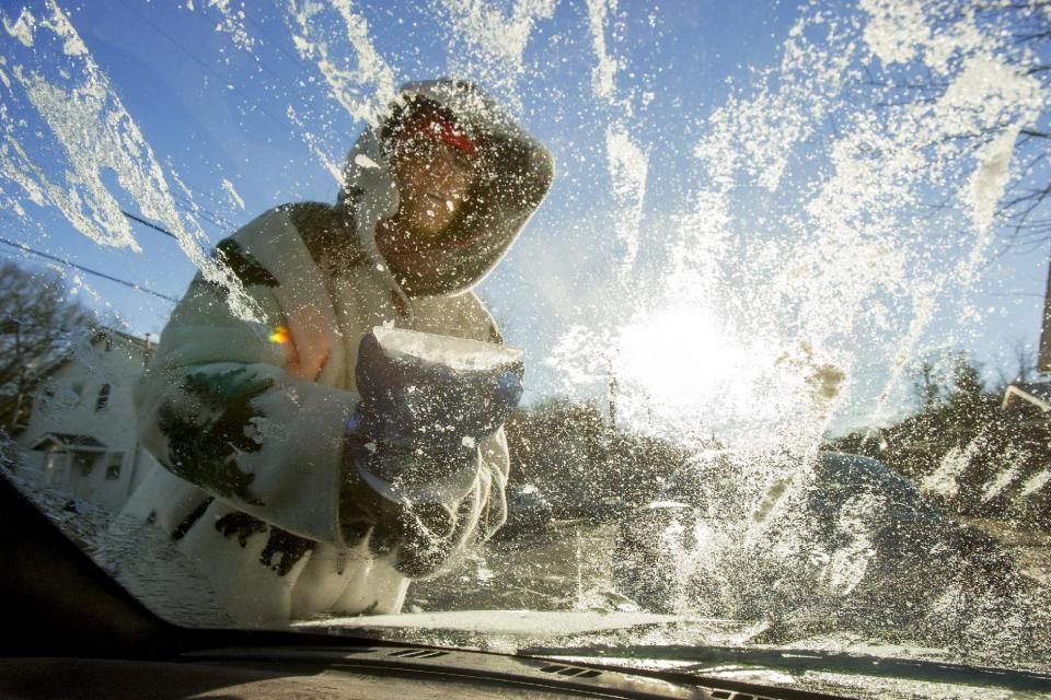 Laurel O'Connor, of Bowling Green, Ky., works to scrape ice off of her windshield before driving, Monday, Jan. 6, 2013, in Bowling Green. Temperatures were expected to plummet further Monday, bringing dangerous cold to parts of the U.S. (AP Photo/Daily News, Alex Slitz)