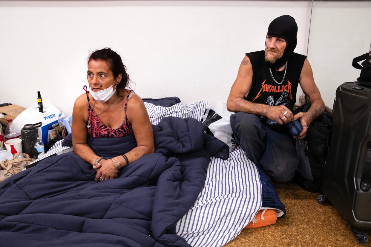 Maria Salazar and her partner, Shawn Sheets, seek relief from the extreme heat inside the cooling center at Demuth Community Center in Palm Springs on Aug. 15, 2023. The couple are homeless.