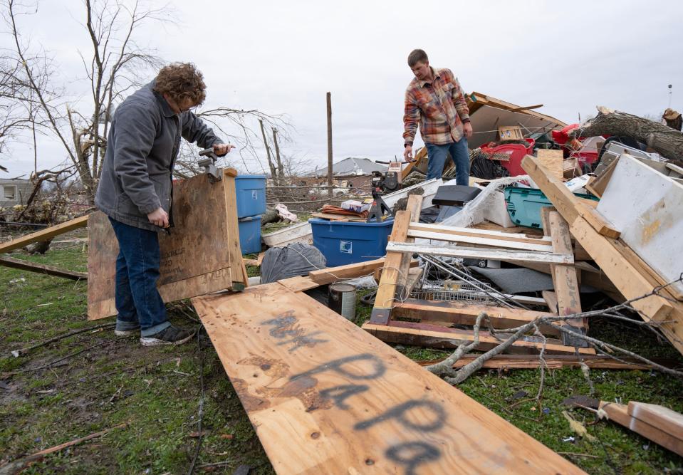 Austin Cunningham, left, and his friend Austin Holmes salvage what they can from their house Saturday, April 1, 2023, after a tornado ripped through a community in Sullivan, Ind.