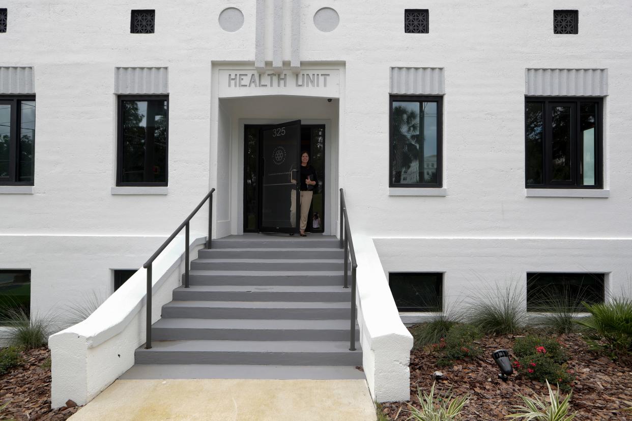 North American Properties Vice President of Development Lindsey Magura stands in the doorway of the company's new construction offices, housed in the historic Leon County Health Unit on East Gaines Street just above Cascades Park Wednesday, July 24, 2019. 
