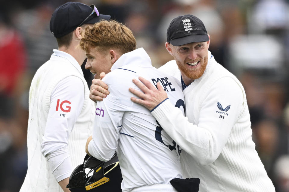 Ollie Pope of England is hugged by captain Ben Stokes, right, after dismissing Daryl Mitchell of New Zealand on the second day of the second cricket test between England and New Zealand at the Basin Reserve in Wellington, New Zealand, Saturday, Feb. 25, 2023. (Andrew Cornaga/Photosport via AP)