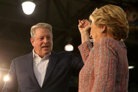 U.S. Democratic presidential nominee Hillary Clinton (R) and former Vice President Al Gore shake hands after talking about climate change at a rally at Miami Dade College in Miami, Florida, U.S. October 11, 2016. REUTERS/Lucy Nicholson