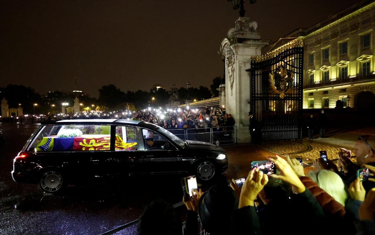 Crowds watch the hearse carrying the coffin of Queen Elizabeth II arrive at Buckingham Palace - ANDREW BOYERS /REUTERS