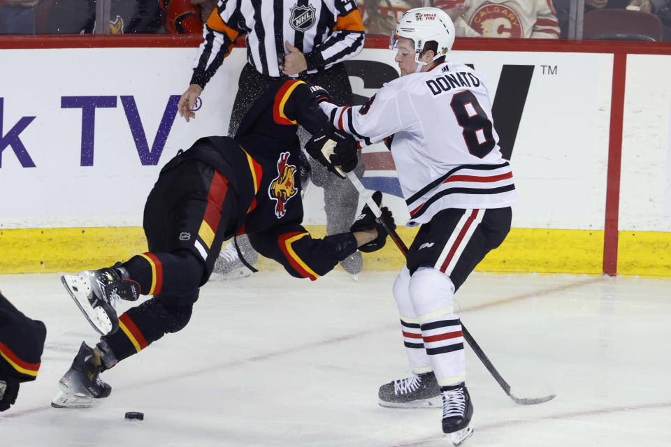 Chicago Blackhawks' Ryan Donato, right, checks Calgary Flames' Noah Hanifin during the second period of an NHL hockey game Saturday, Jan. 27, 2024, in Calgary, Alberta. (Larry MacDougal/The Canadian Press via AP)