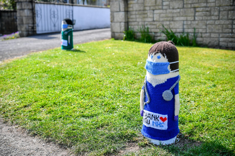 Two knitted NHS doctors are fitted over bollards outside a house in Oldland Common, South Gloucestershire, as the UK continues in lockdown to help curb the spread of the coronavirus.