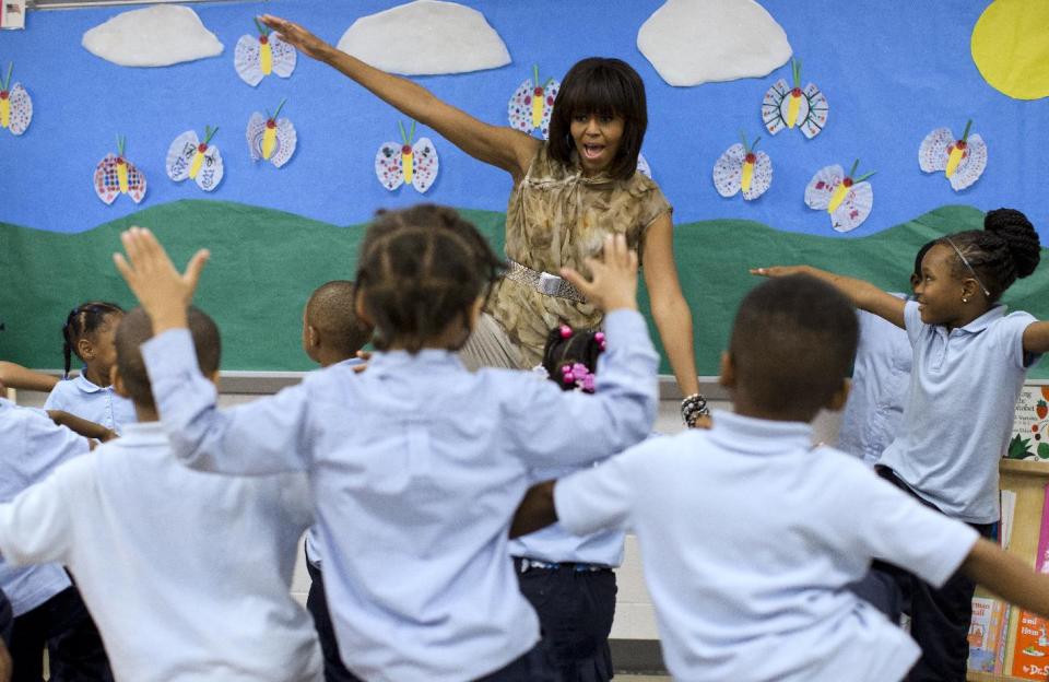 First lady Michelle Obama dances with a pre-Kindergarten class at Savoy Elementary School in Washington, Friday, May 24, 2013. The Savoy School was one of eight schools selected last year for the Turnaround Arts Initiative at the President's Committee on the Arts and Humanities. Turnaround Arts Schools use the arts as a central part of their reform strategy to improve low performing schools (AP Photo/Evan Vucci)