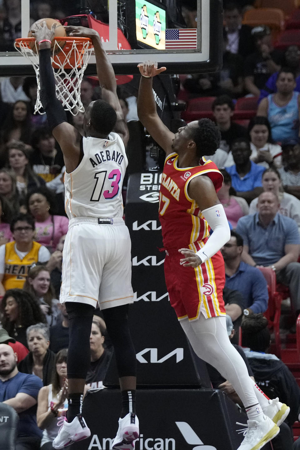 Miami Heat center Bam Adebayo (13) dunks the ball against Atlanta Hawks forward Onyeka Okongwu (17) during the first half of an NBA basketball game, Monday, March 6, 2023, in Miami. (AP Photo/Wilfredo Lee)