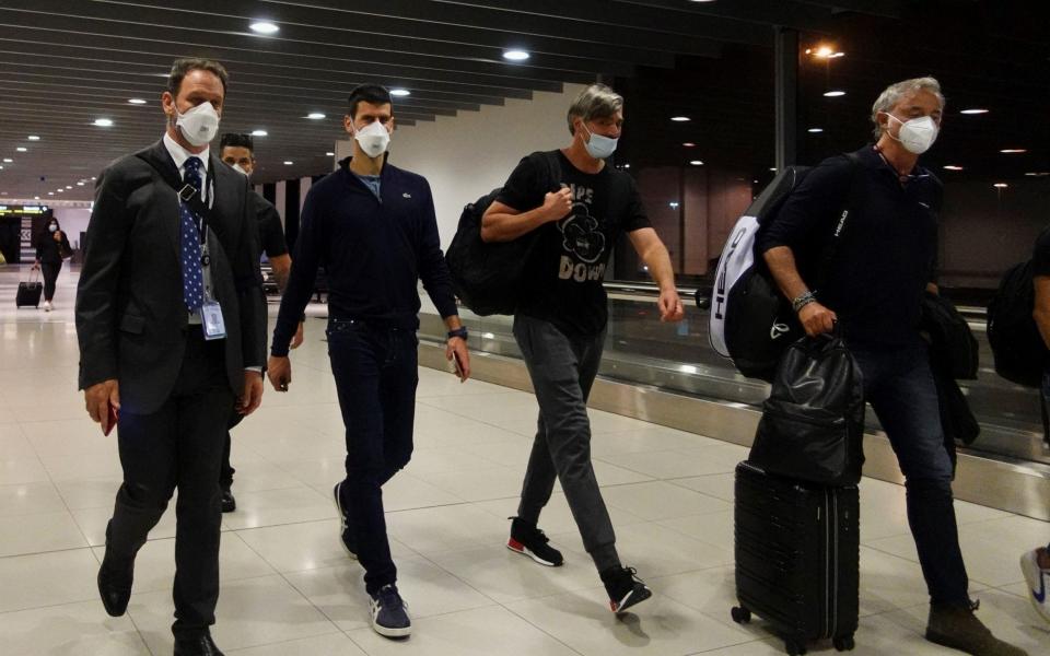 Novak Djokovic walks in Melbourne Airport before boarding a flight - REUTERS