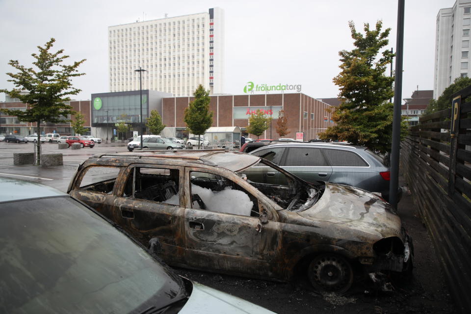 Burned cars parked at Frolunda Square in Gothenburg, Tuesday, Aug. 14, 2018. Masked youth torched dozens of cars overnight in Sweden and threw rocks at police, prompting an angry response from the prime minister, who on Tuesday spoke of an "extremely organized" night of vandalism. (Adam Ihse/TT via AP)
