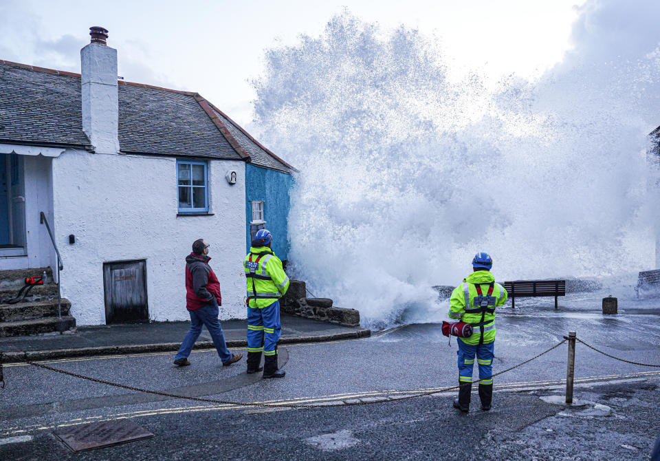 ST IVES, ENGLAND - APRIL 09: HM Coastguard personnel look on as waves crash over the harbour wall onto the street on April 09, 2024 in St Ives, Cornwall, England. On Monday, the Met Office issued severe weather warnings for wind across the southern and western coasts of England and Wales, effective until Tuesday afternoon. This follows the turbulent weather over the weekend, when Storm Kathleen, combined with high tides, generated massive waves along the Cornish coast. (Photo by Hugh Hastings/Getty Images)