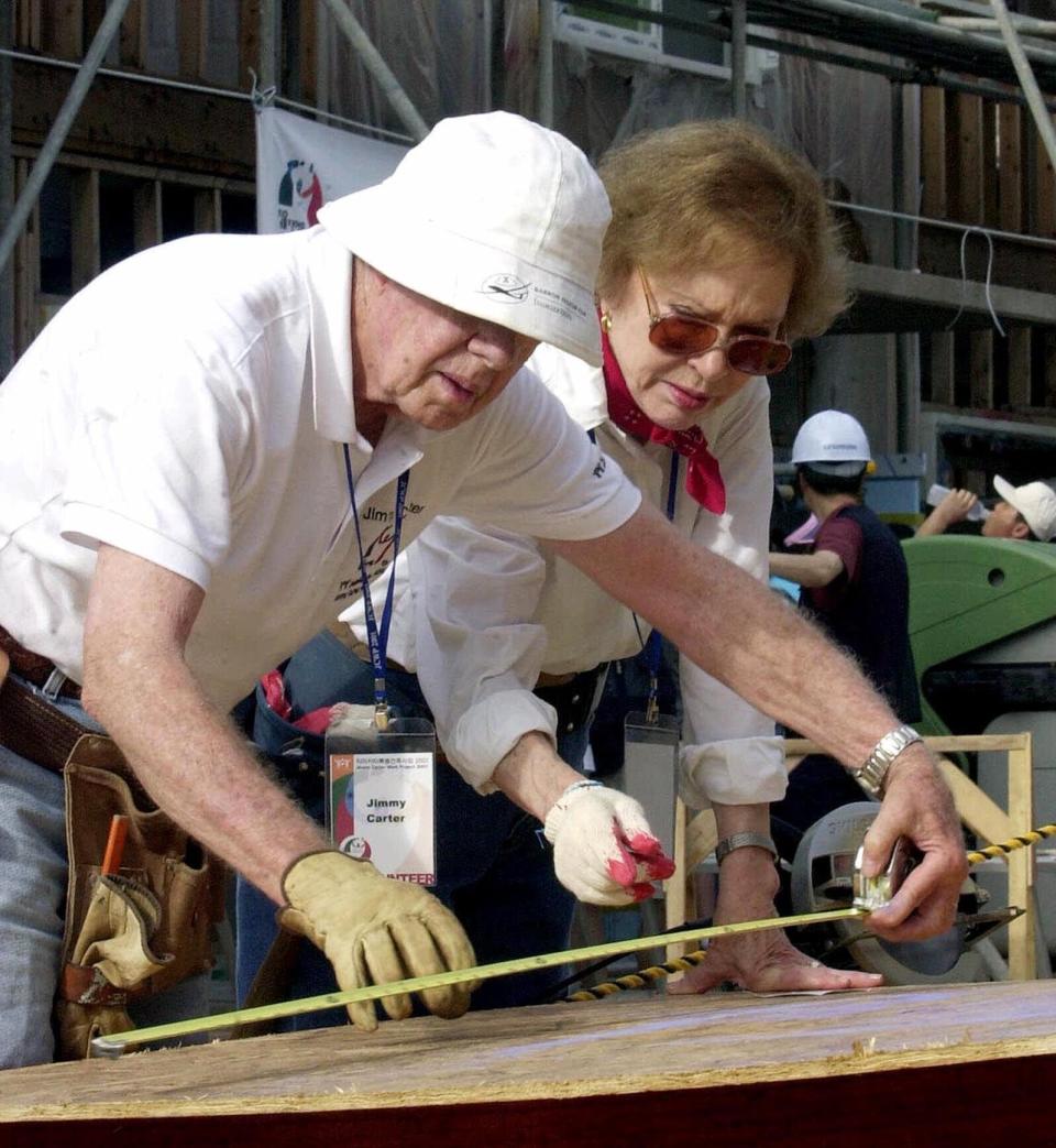 FILE - In this Aug. 6, 2001, file photo former U.S. President Jimmy Carter, left, and his wife Rosalynn help build a house for the Jimmy Carter Work Project 2001, at Asan near Chonan city, south of Seoul, South Korea. Jimmy Carter and his wife Rosalynn celebrate their 75th anniversary this week on Thursday, July 7, 2021. (AP Photo/Yun Jai-hyoung, File)