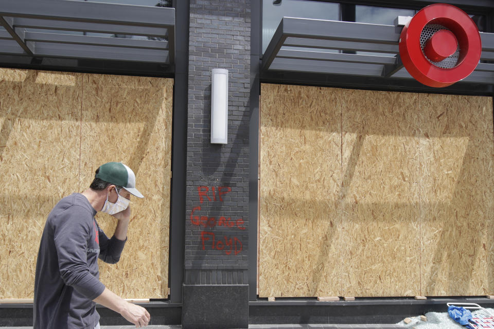 A worker walks past boarded up windows at a Target store in Oakland, Calif., Saturday, May 30, 2020, that was damaged during protests over the death of George Floyd. Floyd died in Minneapolis police custody on May 25. (AP Photo/Jeff Chiu)