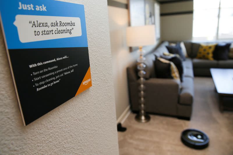 FILE PHOTO: Prompts on how to use Amazon's Alexa personal assistant are seen as a wifi-equipped Roomba begins cleaning a room in an Amazon ‘experience center’ in Vallejo