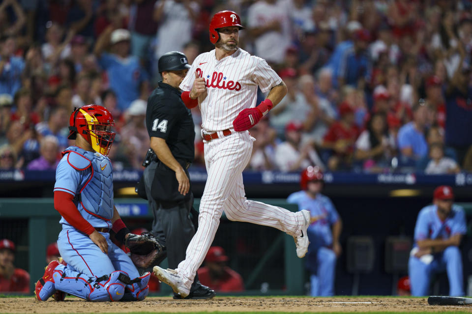 Philadelphia Phillies' Jake Cave, front right, comes in to score on a single by Bryce Harper as St. Louis Cardinals catcher Willson Contreras, left, looks on during the third inning of a baseball game, Saturday, Aug. 26, 2023, in Philadelphia. (AP Photo/Chris Szagola)