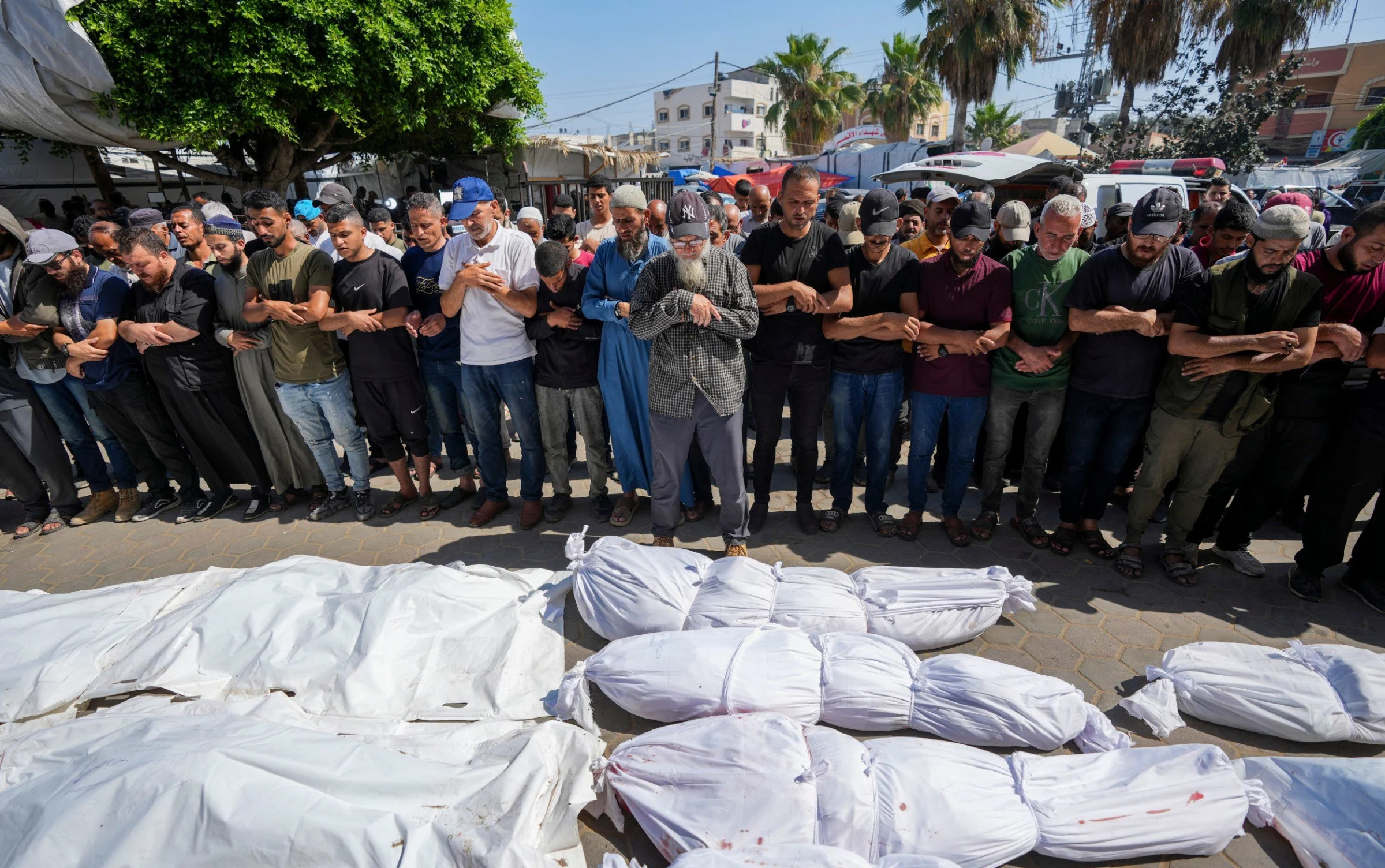 Palestinians mourn relatives killed at the UN-run school after an Israeli airstrike - Israel bombs UN school as IDF accused of using white phosphorous